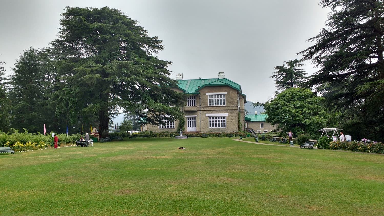 The green-roofed Chail Palace behind a lawn and tall deodar trees