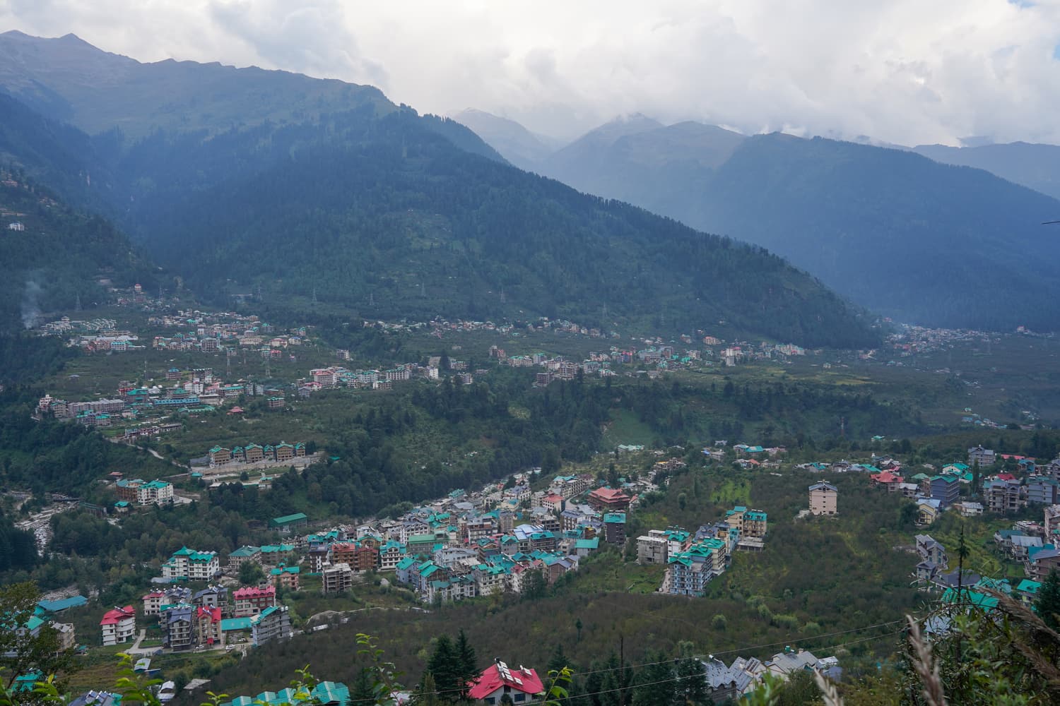 The valley at Manali, with the town spread beneath forested mountains
